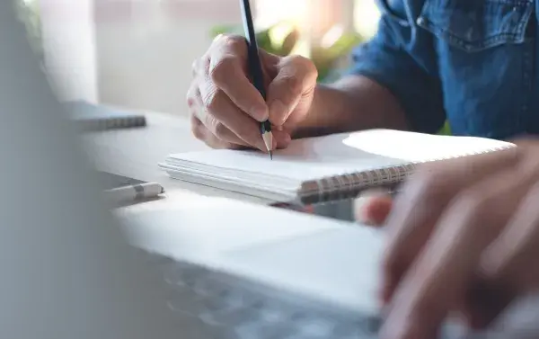 Man using a notebook and laptop