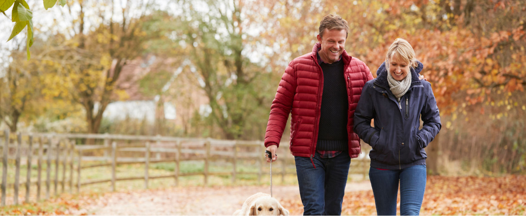 Man and women walking dog in the autumn