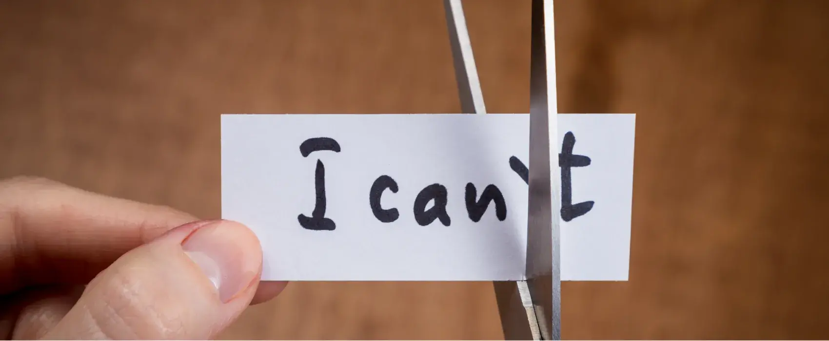 Scissors cutting through the t on 'I can't' to make I can