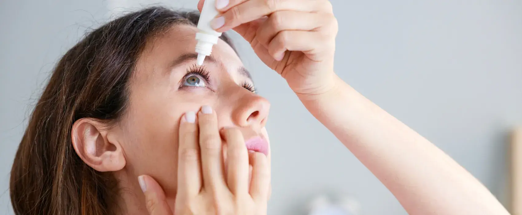 Women putting eye drops in