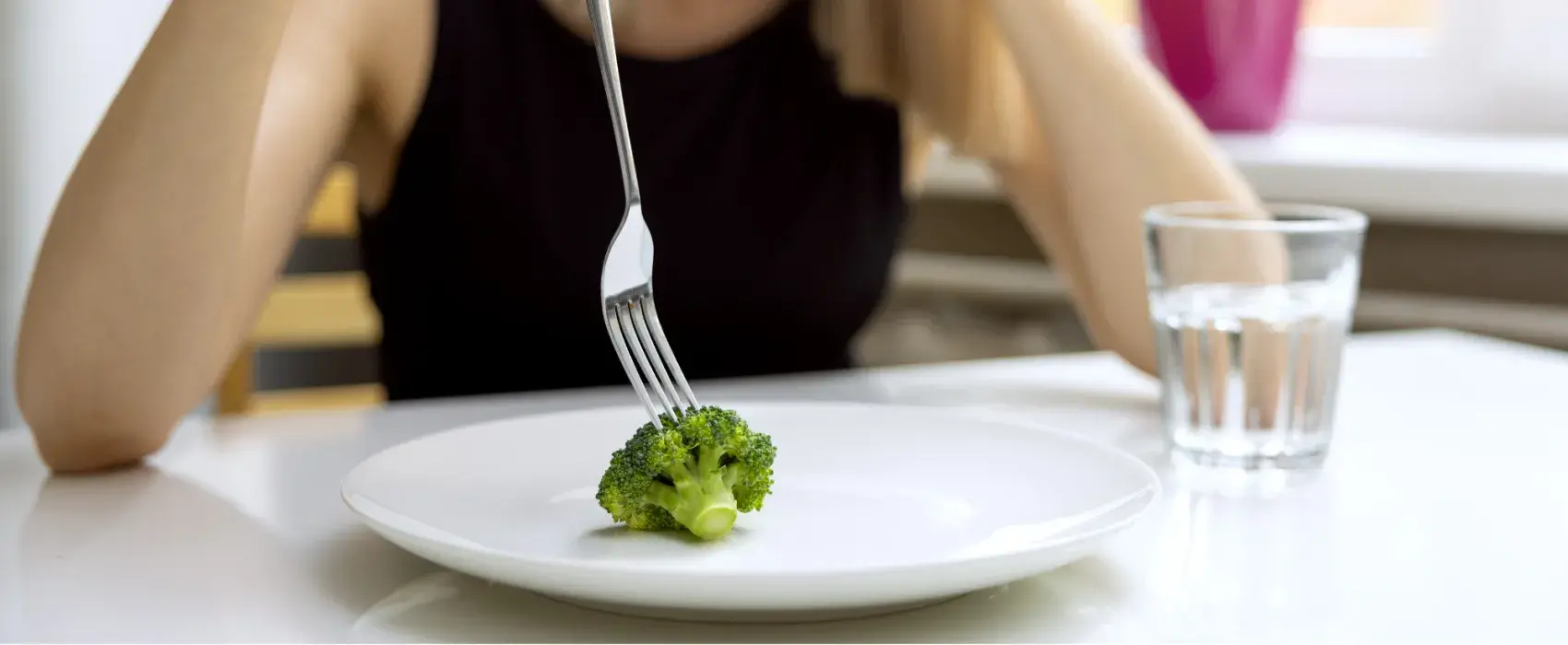 Single piece of broccoli on a plate