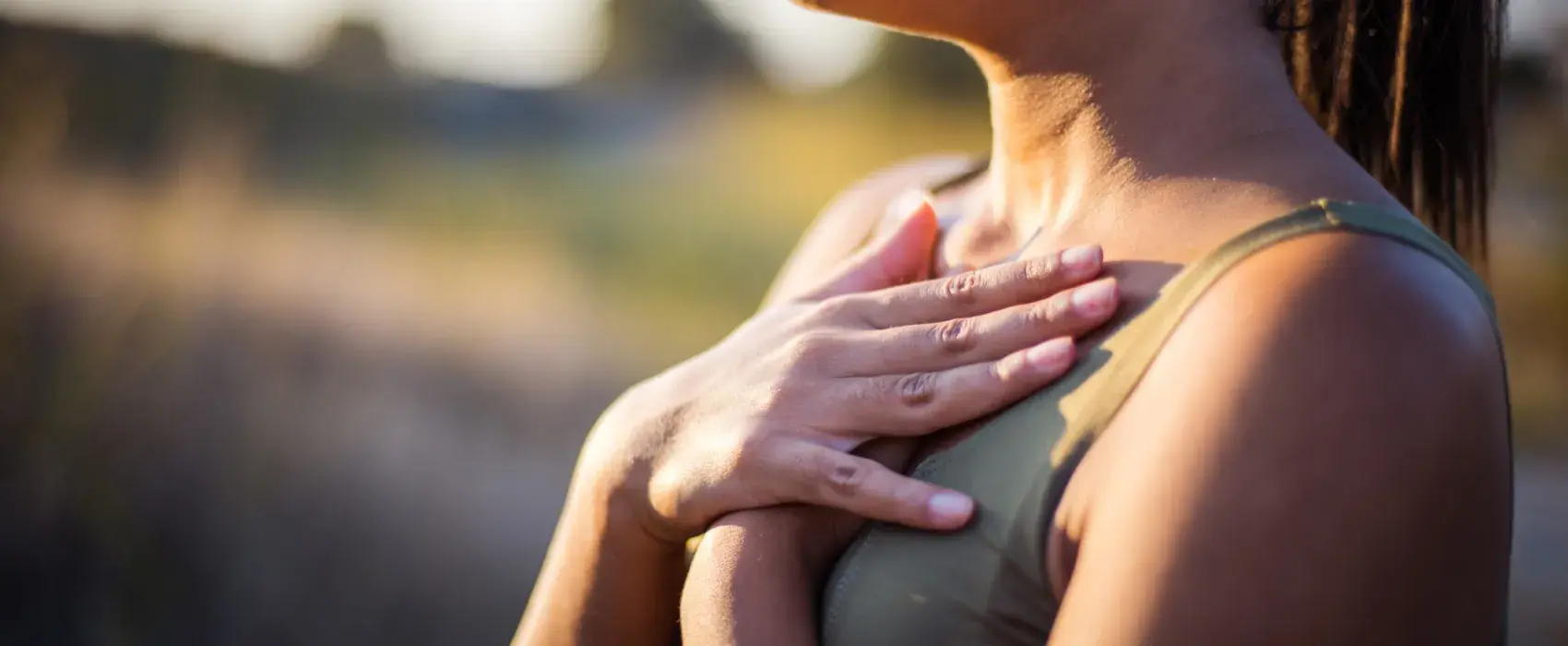 Woman taking a deep breath with hands on chest