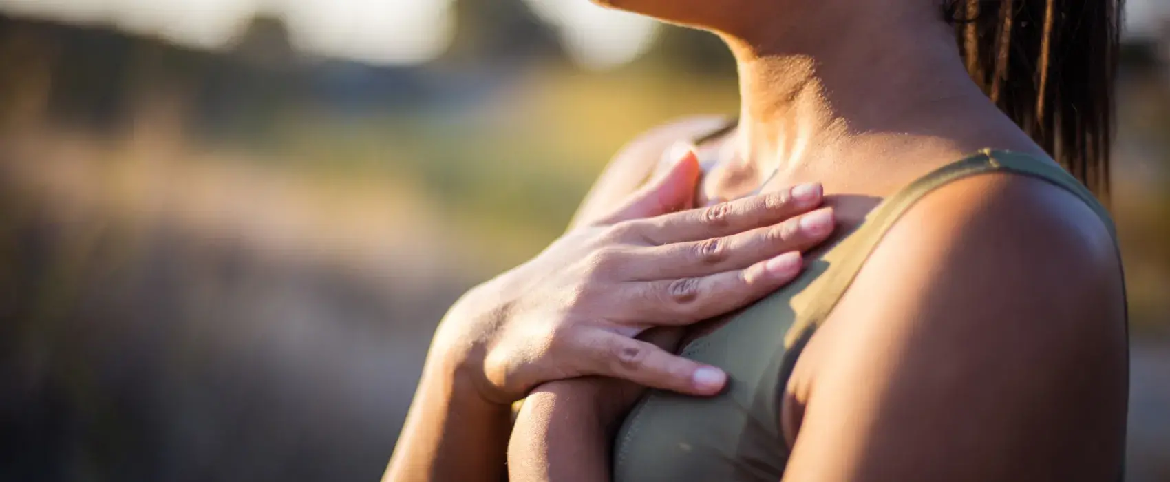 Woman taking a deep breath with hands on chest