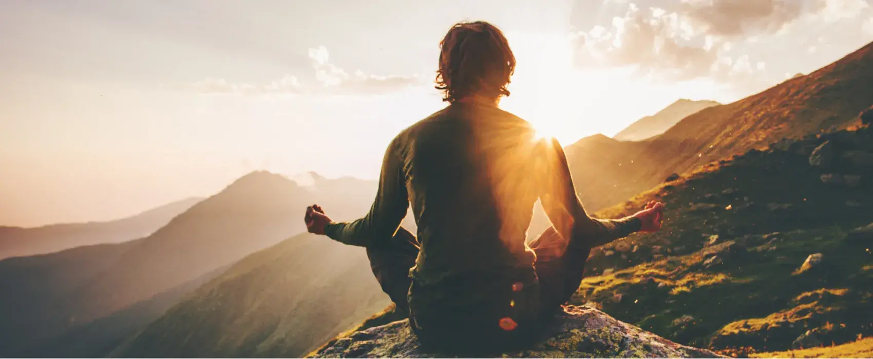 Man meditating at sunset