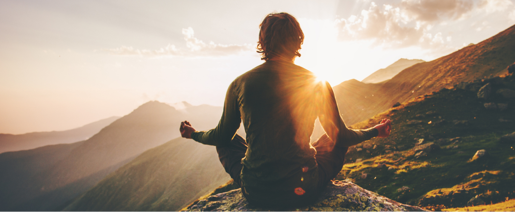 Man meditating at sunset