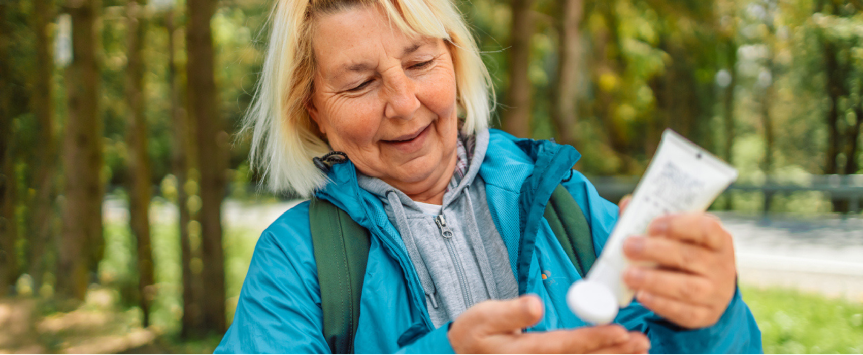 Woman applying suncream whilst on a walk