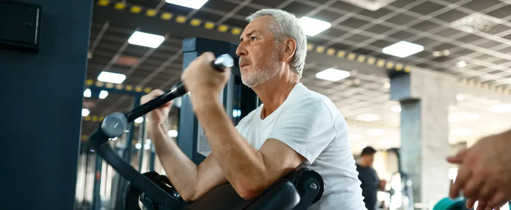 Older man on a weight machine at the gym