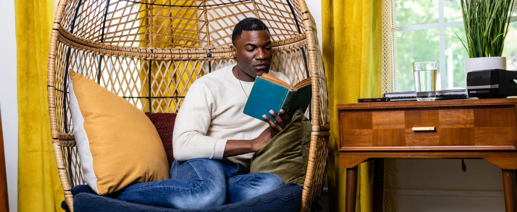 Man in egg chair reading a book