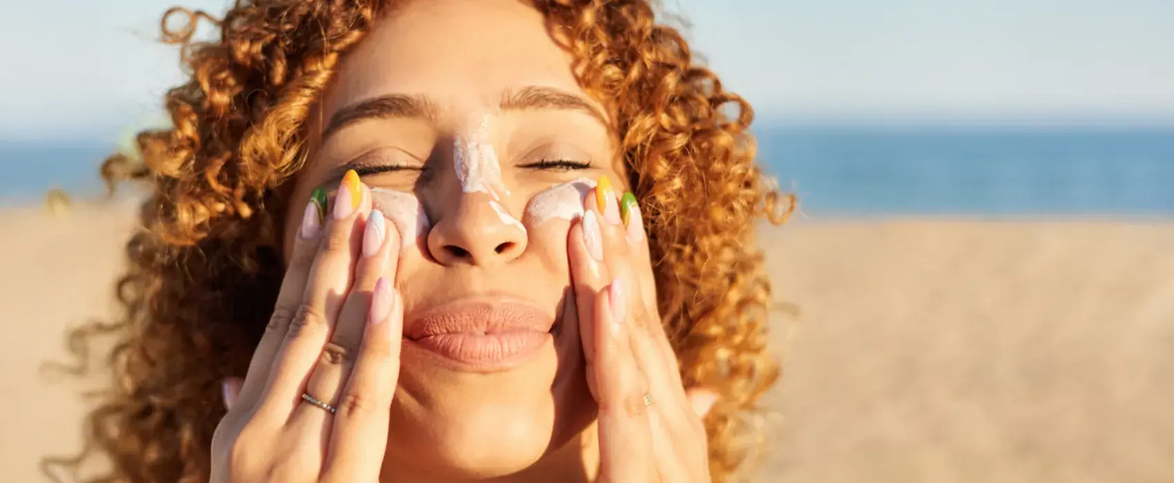 Woman putting sunscreen on her face