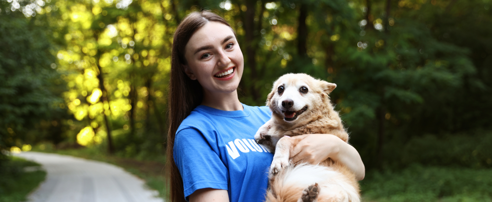 Woman volunteering looking after happy dog